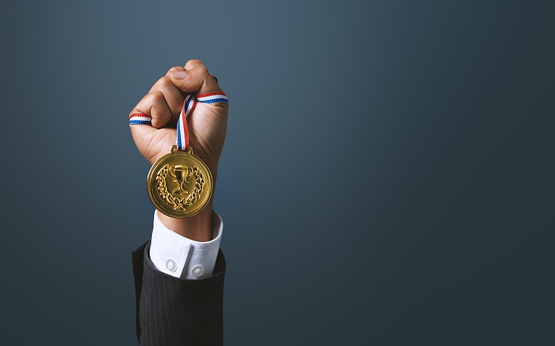 一个拿着金牌的商人。在商业上取得成功，实现商业目标。