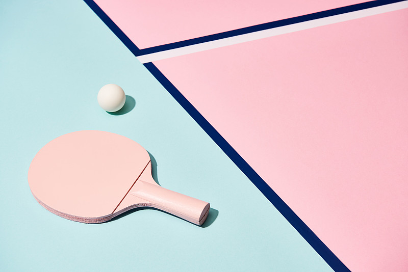 网球拍和球在粉彩背景与蓝色线