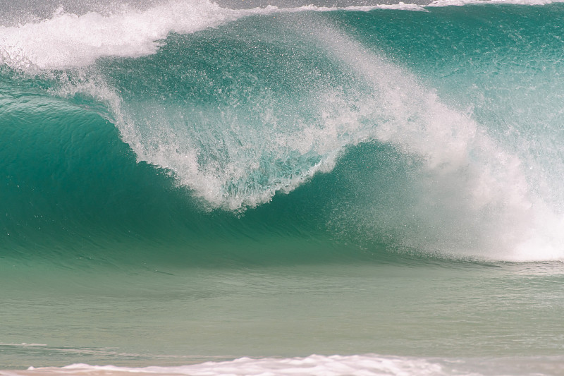巨大的海浪冲击着海滩上的一个岛屿