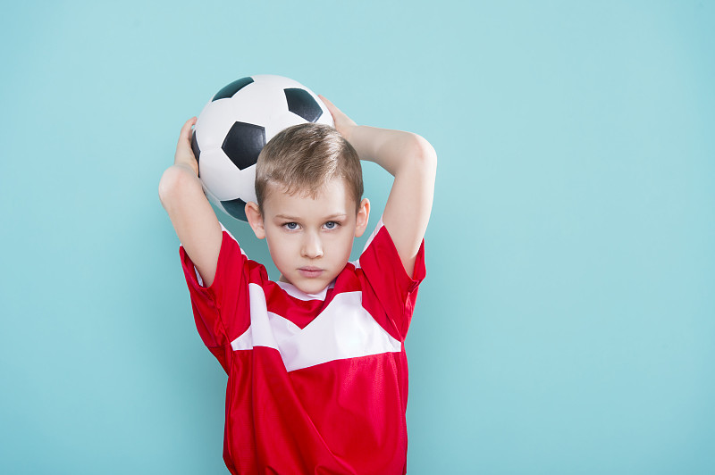 男孩与足球在蓝色背景
