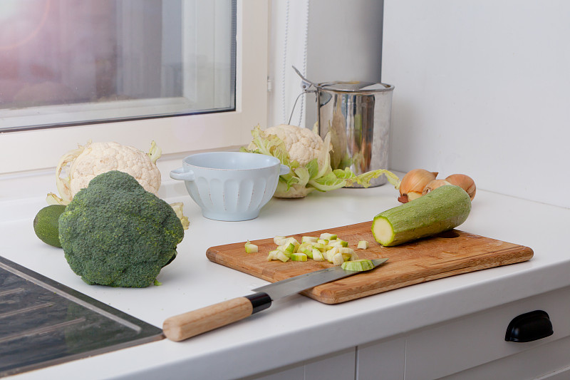 厨房里，空木桌上放些新鲜的蔬菜，比如鳄梨、洋葱和骨髓