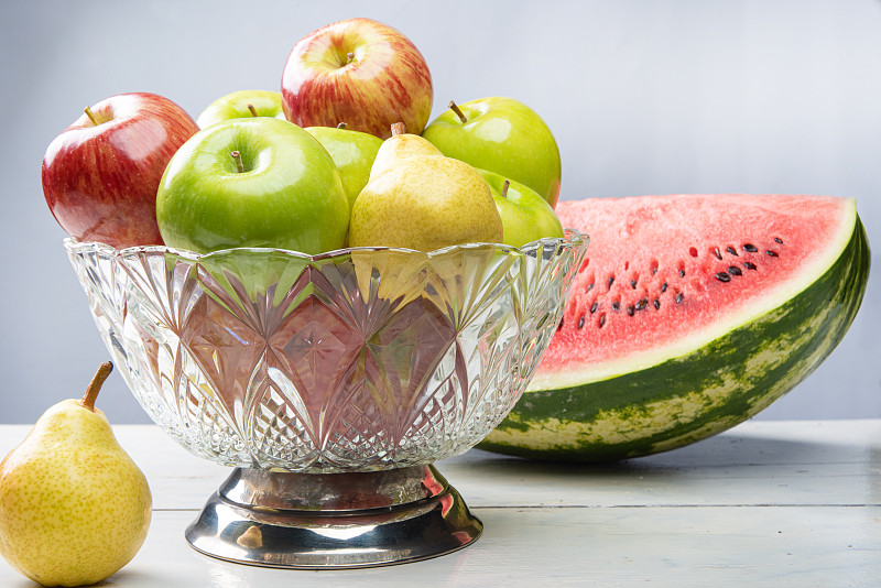 水果排列在白色的木质表面和白色的背景。有选择性的重点。