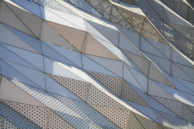 铝复合板或穿孔板覆层在现代建筑立面上，抽象的建筑背景概念。