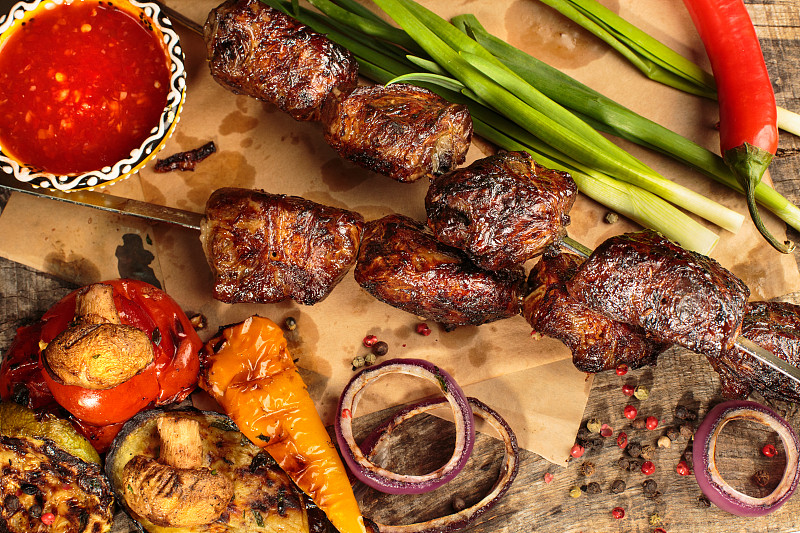 Shashlik或shish烤肉串准备在烧烤架上热木炭。在金属串上烤猪肉片。