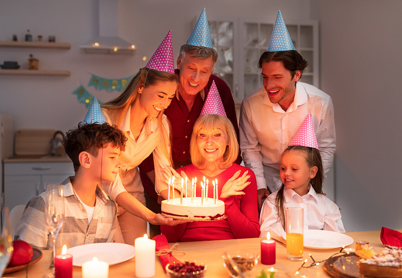 多代同堂的家庭在晚上举行生日聚会，送大妈蛋糕，在家里欢度节日