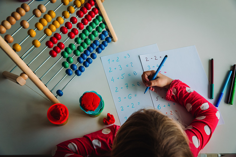 小女孩在学数数，孩子在做作业
