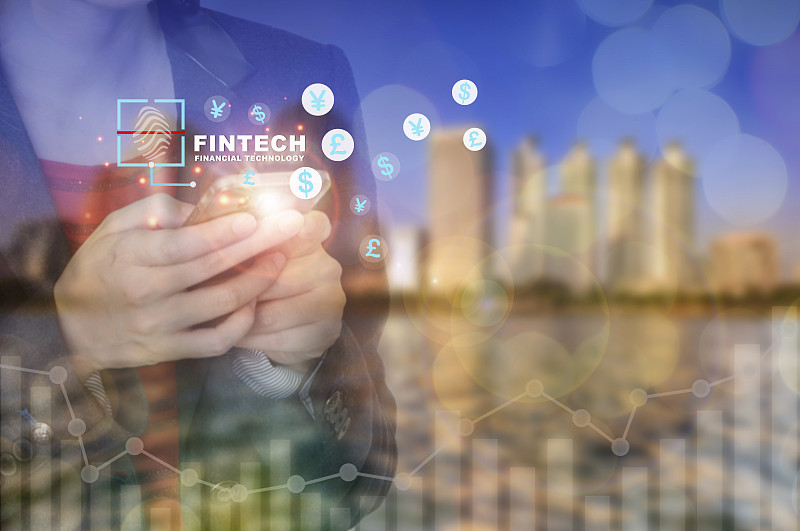 商业女性使用智能手机的城市景观背景