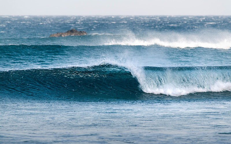 小波在沙滩上形成一个管子。美丽的蓝色海水