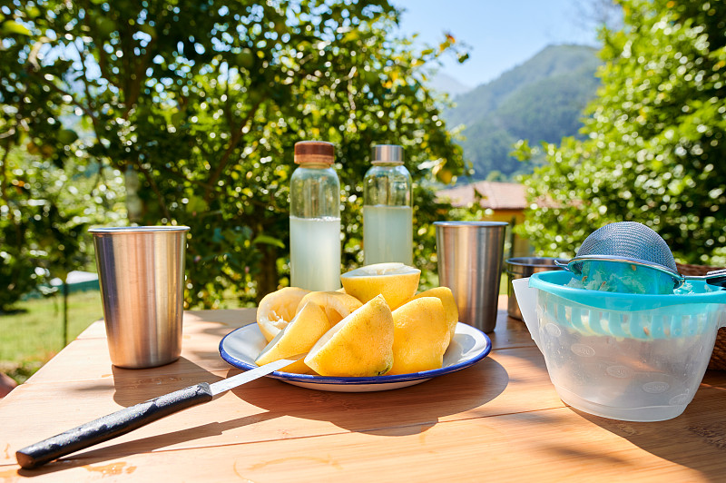 在乡村一个阳光明媚的早晨，一些新鲜的柠檬和一些放在木桌上的柠檬