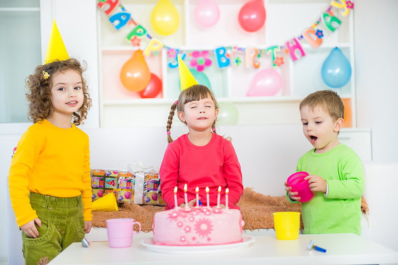 孩子们吹灭生日蛋糕上的蜡烛