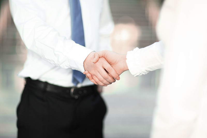 特写，一个商人和一个女商人的握手。