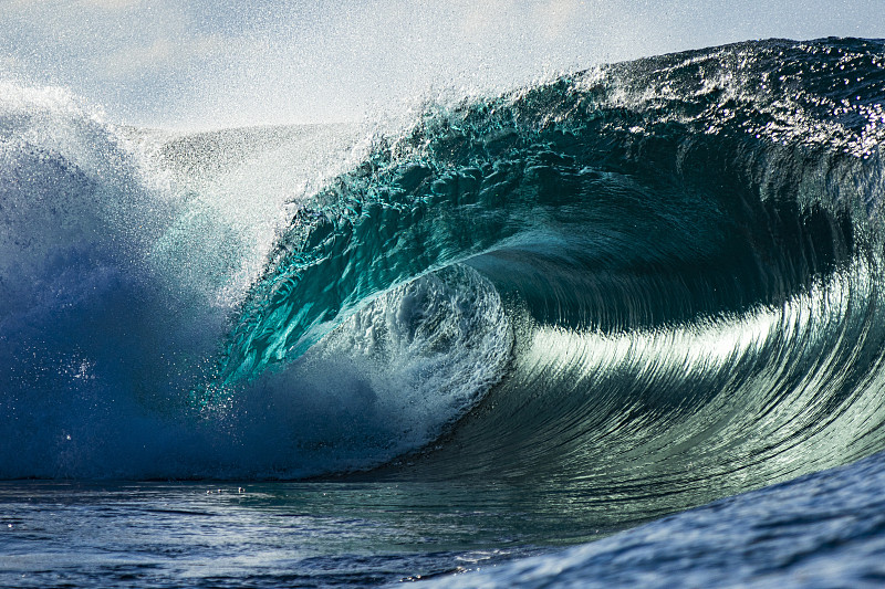 完美而有力的蓝绿色波浪打破在一个阳光明媚的下午开放的海洋
