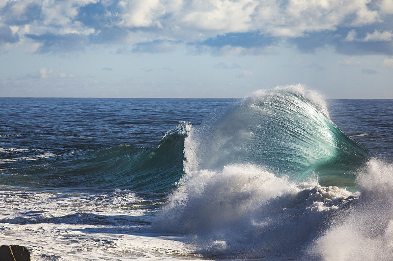 沿多岩石的海岸线起伏的波浪