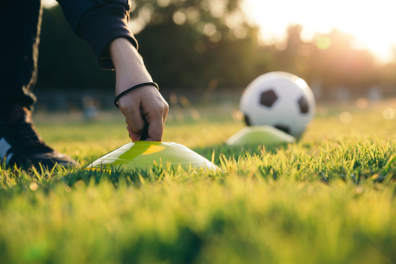 教练员准备足球训练设备。