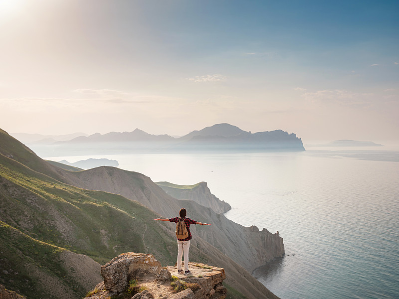 一个年轻的亚洲女人背着背包在夏天徒步旅行。