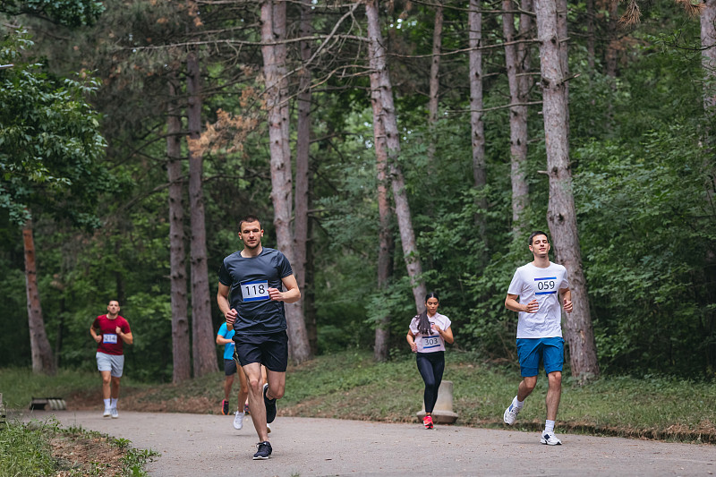 一大群不同年龄的马拉松选手在柏油路上比赛