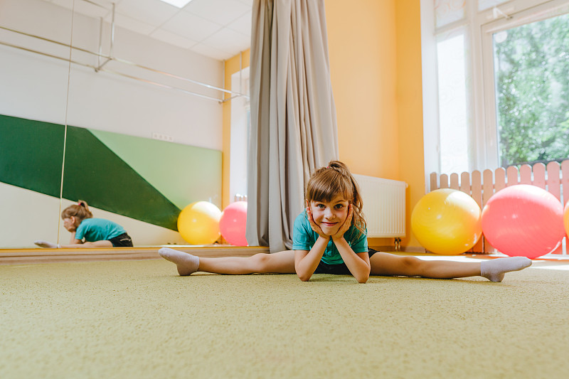 小女孩坐在麻绳上看着相机