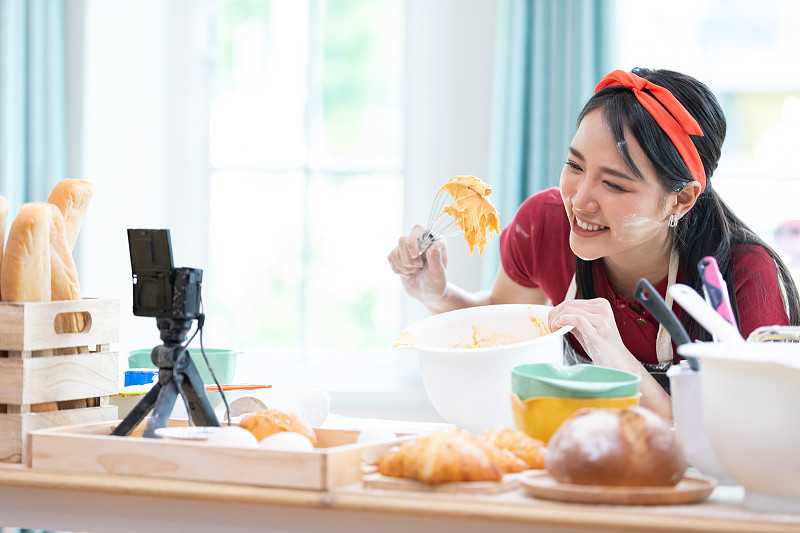 近距离拍摄女博主做面包，在碗里搅拌奶油，并从摄像机在线记录流直播视频
