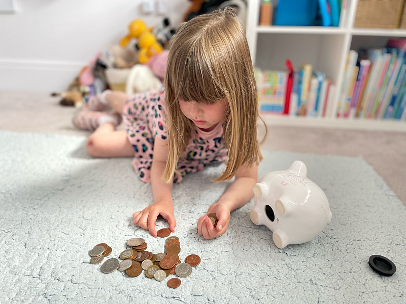 女孩在数她存钱罐里的钱