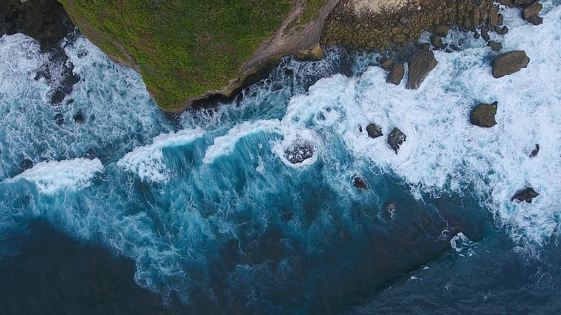 从空中俯瞰巴厘岛的岩石和蓝色海浪