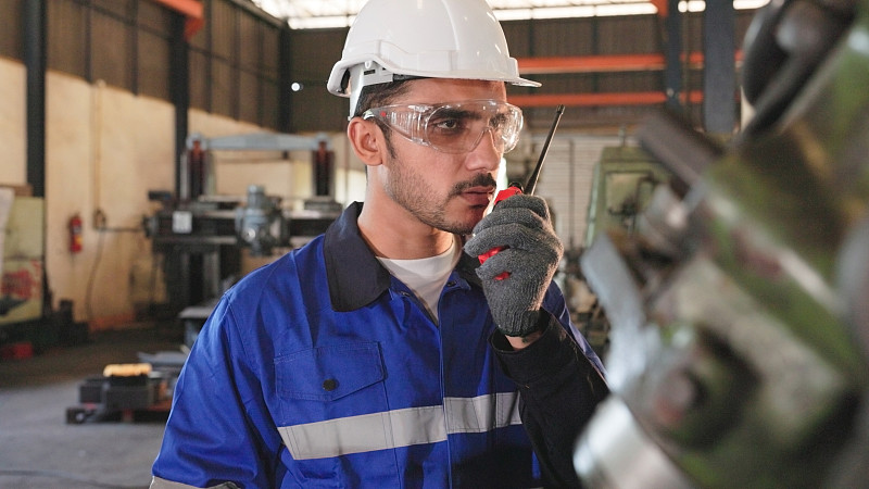 工厂工程师使用对讲机与团队沟通。