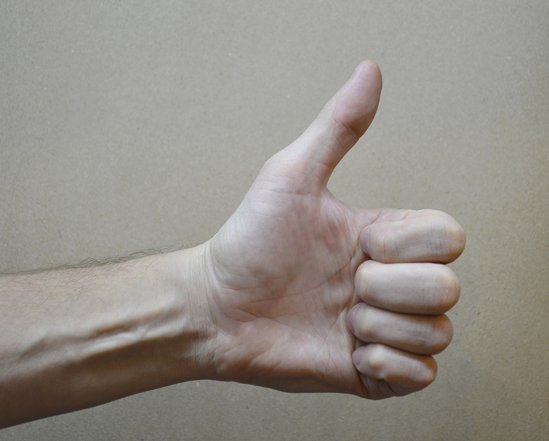 男性的手向上伸出手指，表示赞同和同意
