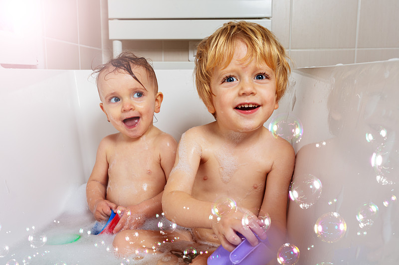 两个小婴儿笑着玩肥皂泡