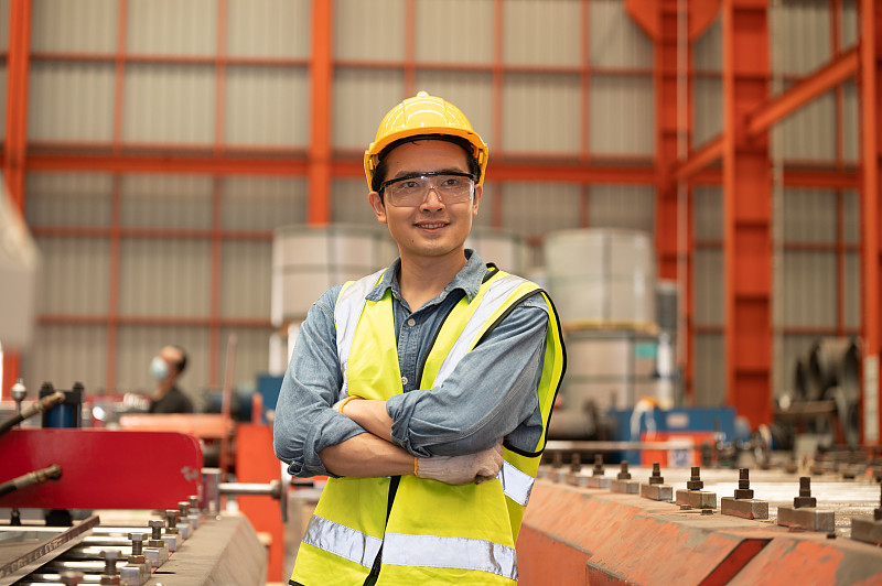 亚洲人工程师在工厂辛勤工作，工人员工安全帽安全控制机厂