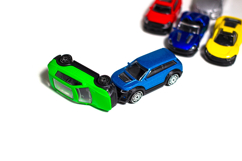 玩具车相撞事故之间的绿色汽车和蓝色的汽车在白色的背景。