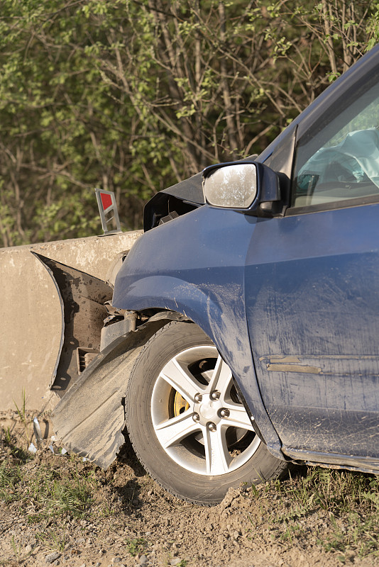 车祸特写。汽车撞上了郊区土路上的混凝土道路围栏。危险驾驶。