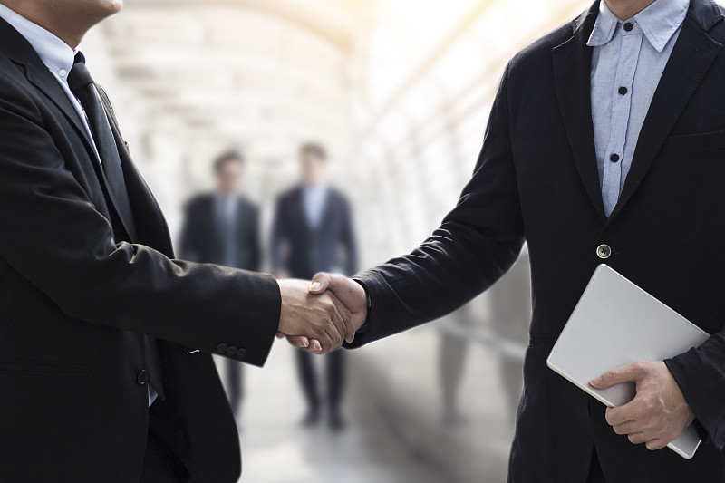 成功的商务谈判理念，商务人士在完成会议后握手或设定目标和计划成功的方式