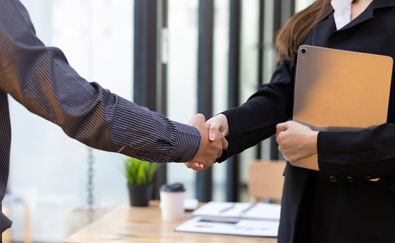 握手。商人与同事握手，同意商业伙伴关系。