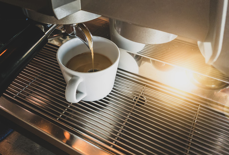 特写浓缩咖啡从咖啡机由专业咖啡酿造。