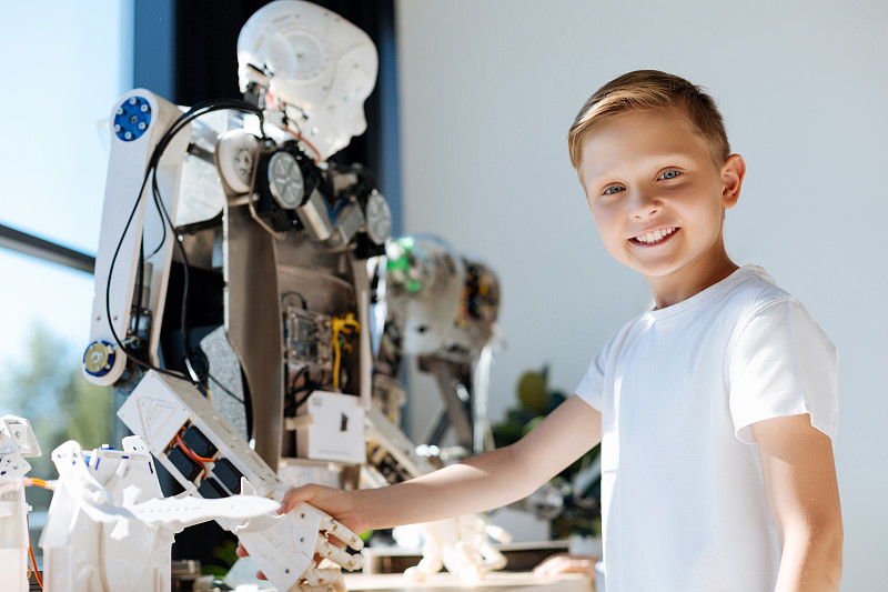 可爱的孩子与人类机器人握手