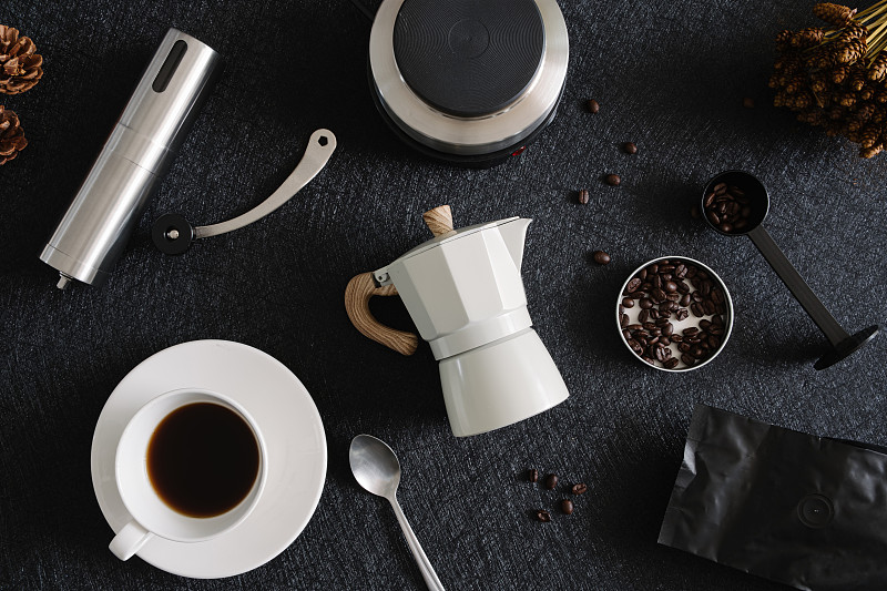 咖啡杯和摩卡壶的黑色桌子背景在厨房，咖啡店。