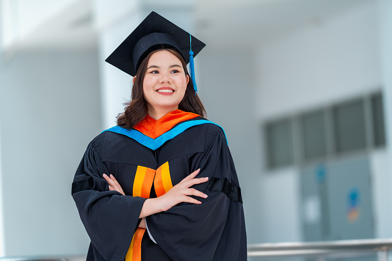 年轻的亚洲女性大学毕业生的肖像，毕业礼服和帽子，教育理念。