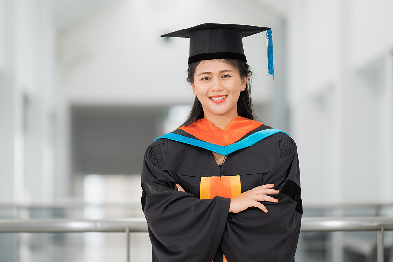 年轻的亚洲女性大学毕业生的肖像，毕业礼服和帽子，教育理念。