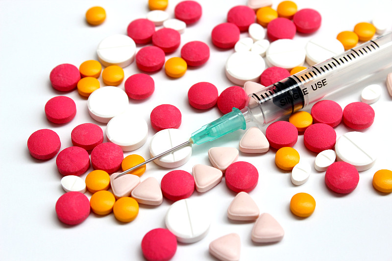 将几种药物片剂和3ml注射器分离在白底上