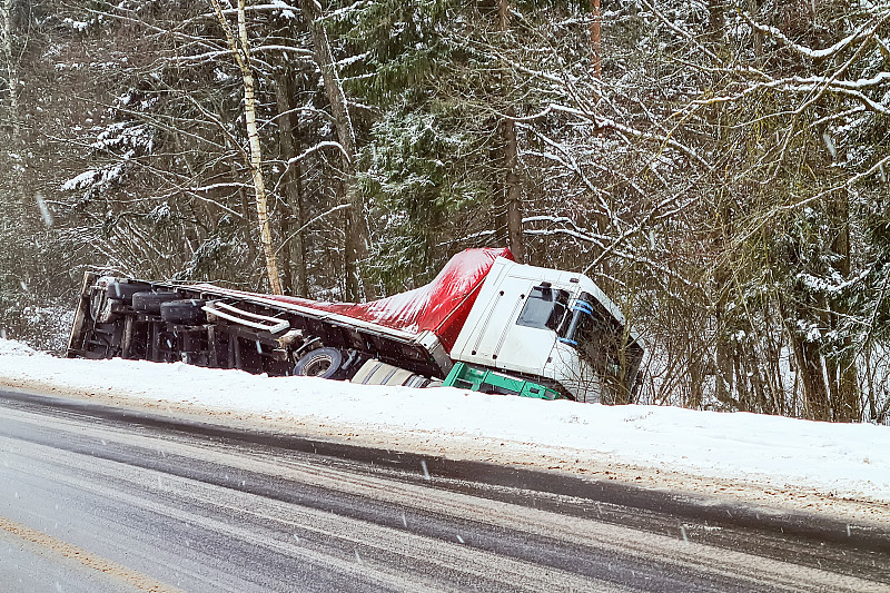 车祸。长卡车倒挂在路边