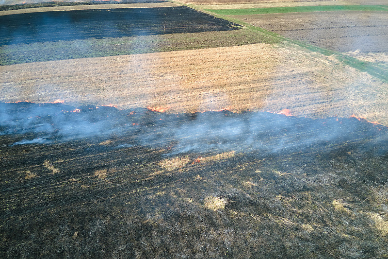旱季燃烧着红色火焰的草地鸟瞰图。自然灾害和气候变化的概念