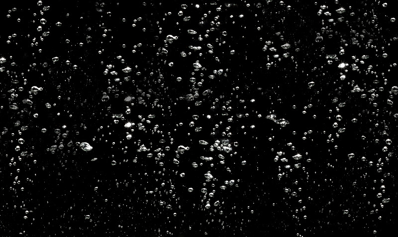 摘要水背景。气泡水漂浮在黑色背景上。