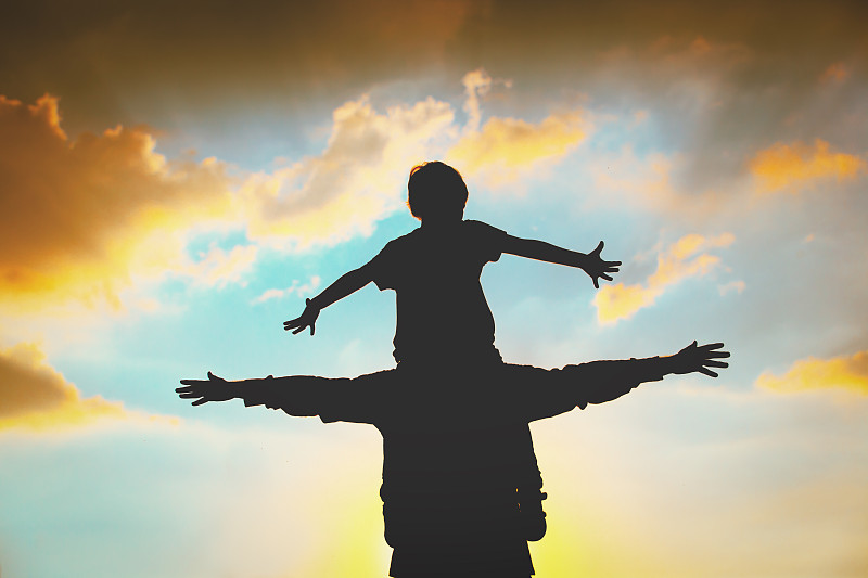 父亲和儿子在玩日落