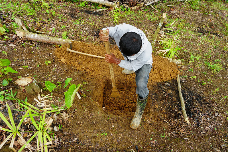 用铲子挖洞的人-库存照片