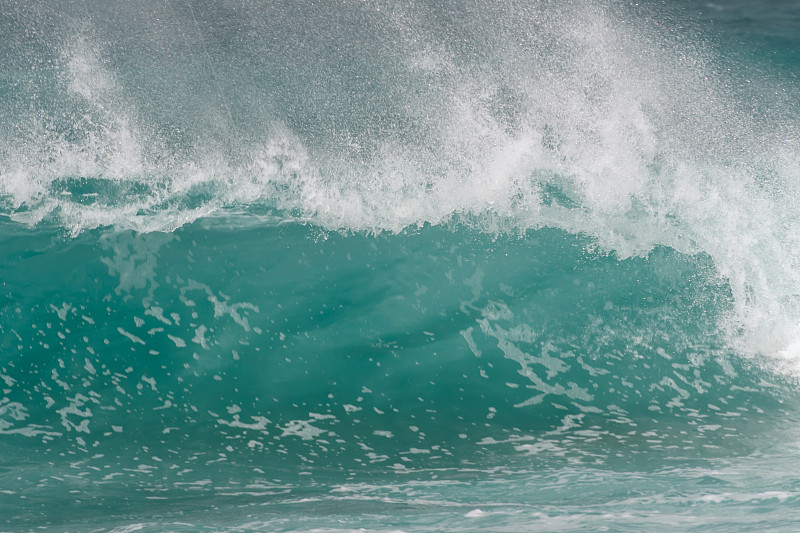 巨大的海浪冲击着海滩上的一个岛屿
