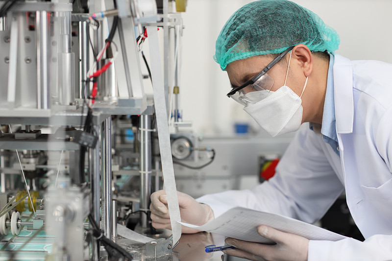 在工厂、制造业和工厂概念的个人防护设备或PPE检查口罩和医用口罩生产线的质量。