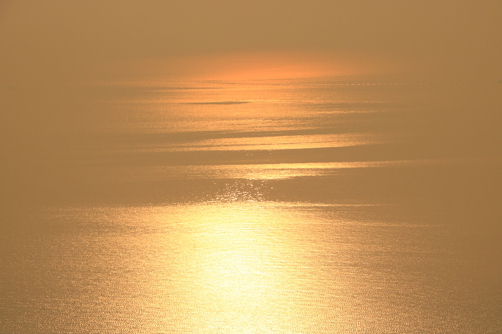 清晨日出之后海面被阳光投射产生的波光粼粼的效果