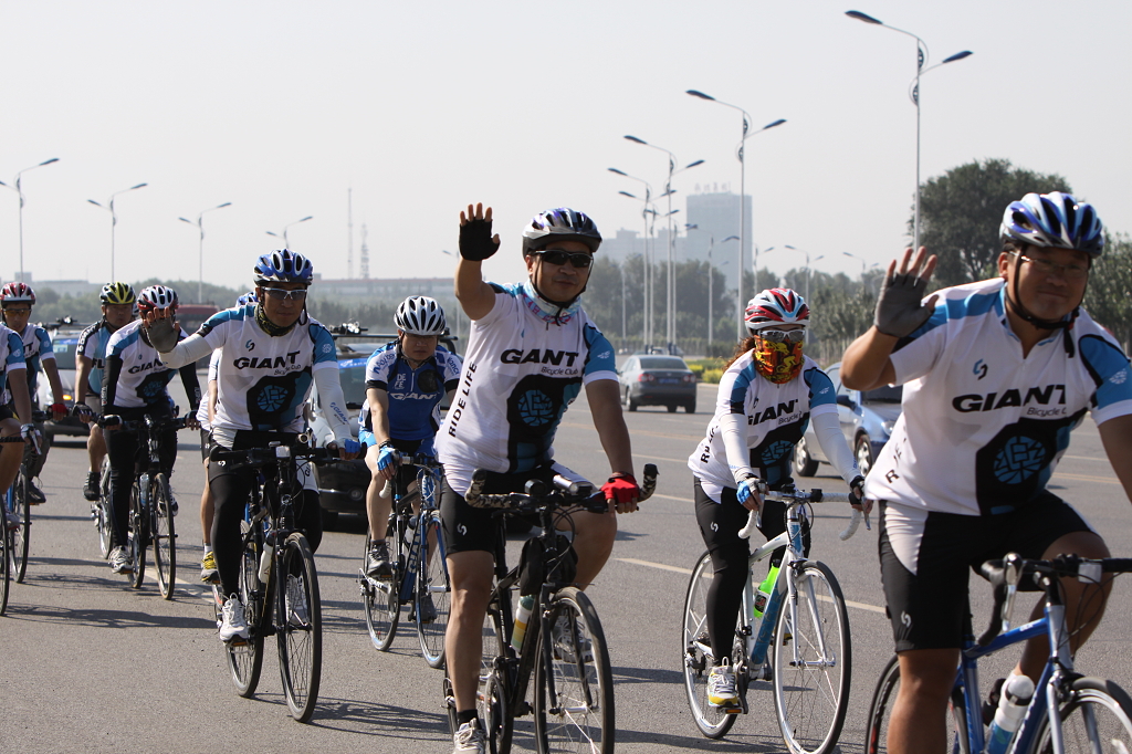 骑行正面拍摄骑行爱好者在公路上快乐骑行