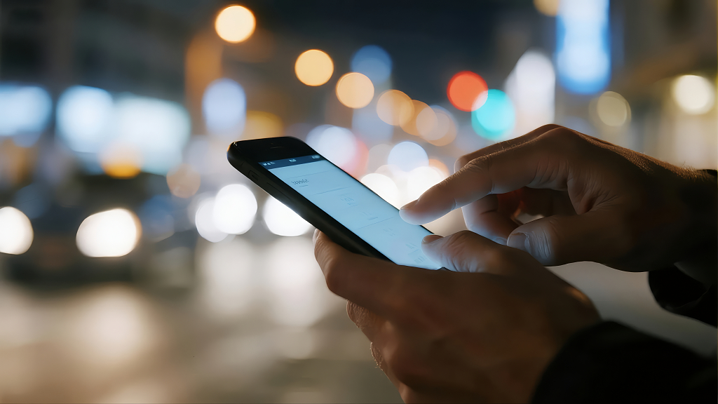 手持手机夜晚城市生活网络科技背景图