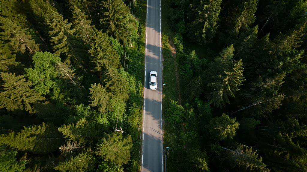 森林公路汽车穿行航拍的自然风光背景图