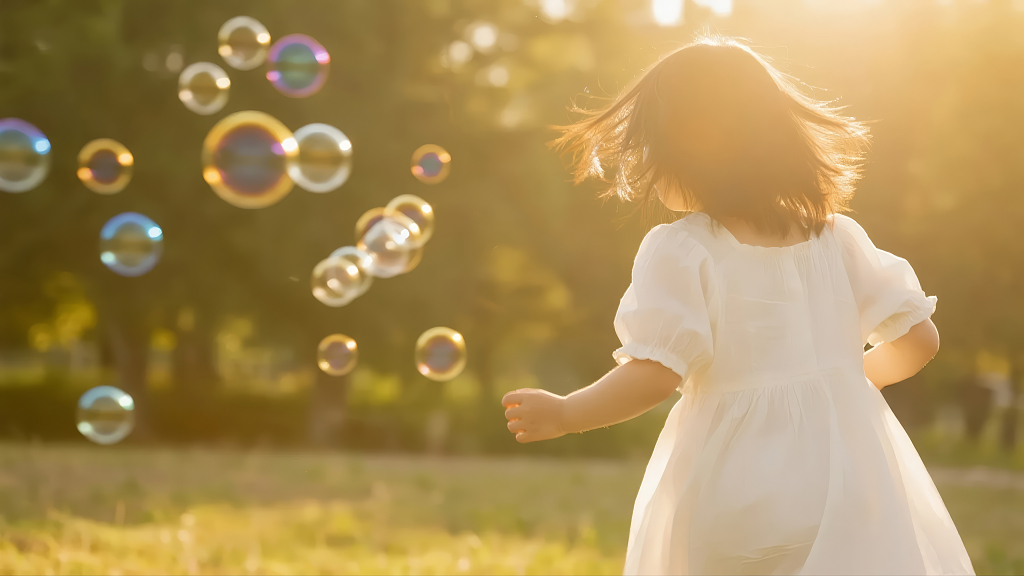 女孩追逐泡泡的快乐童年与梦想背景图